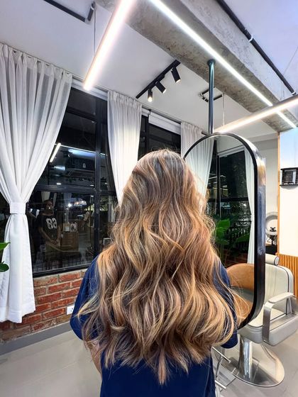 A stunning example of a lived-in brunette with warm, caramel tones. The color adds richness and dimension, and the soft waves make the highlights pop.