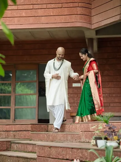 The groom gently leads his bride down the steps of their home, a simple, elegant moment that speaks of partnership and care.