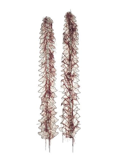 A detailed shot of 'Eye of a Needle' by Surekha, an installation piece shown at the Seattle Art Fair. This work explores gender and identity through fabric, thread, and artificial jasmine.