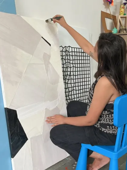 Me at work on a large, geometric abstract painting in my studio. The small blue chair is a humble reminder of childhood creativity.