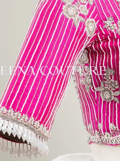Pretty in pink, this raw silk blouse features intricate pearl and silver thread work in a striped pattern. I added floral motifs and delicate danglers on the sleeves for a touch of playful elegance.