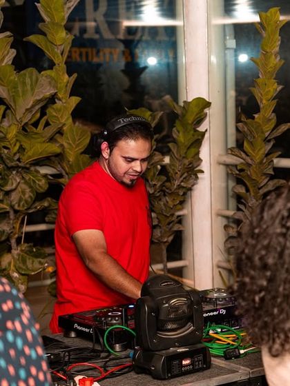 A different angle of me at the decks, surrounded by the lush greenery of the venue.