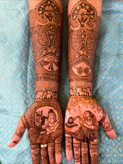This is what I mean by telling your story. This royal wedding design features a beautiful portrait of Shiva and Parvati on the palms, surrounded by intricate patterns, elephants, and the couple's initials, creating a truly divine and personalized bridal mehendi.
