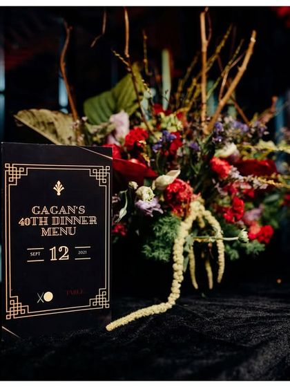 Personalization is key. I designed this custom art-deco-inspired dinner menu for a 40th birthday, which sat next to a dramatic floral arrangement, tying the tablescape into the event's moody and sophisticated theme.
