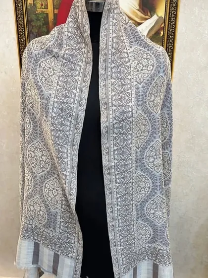 A beautiful pashmina with a delicate, repeating geometric and floral pattern. The light grey and white colour scheme is very chic.