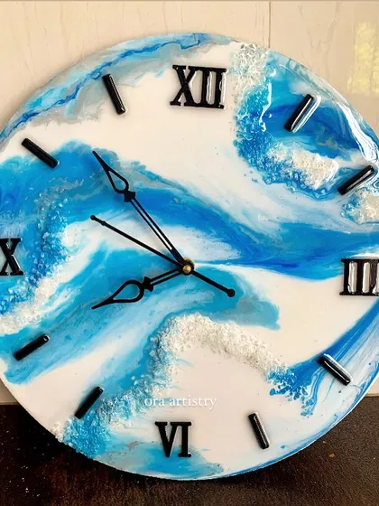 A beautiful blue and white resin clock that perfectly captures the look of crashing ocean waves.