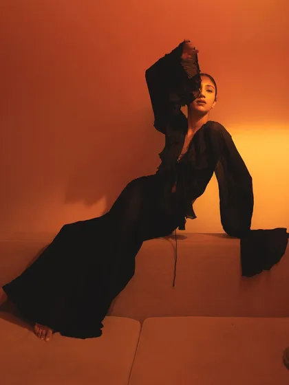 Playing with light and shadow. This look uses a warm, orange-toned light to sculpt the face, with a sleek, pulled-back hairstyle and minimal makeup to let the mood take over.