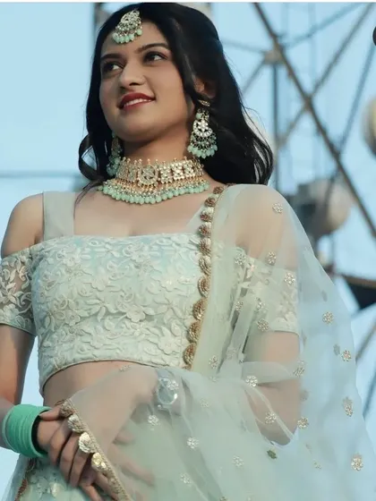 This beautiful mint green cold-shoulder lehenga is a fresh and modern choice for a summer wedding or daytime event. The matching jewellery completes this chic rental look.
