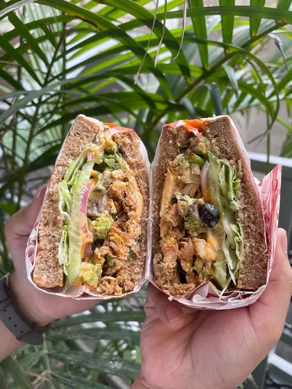 The perfect bite of our Vietnamese BBQ Chicken Sandwich. This close-up shows the rich texture and vibrant colors of the ingredients, promising a delicious and satisfying experience.