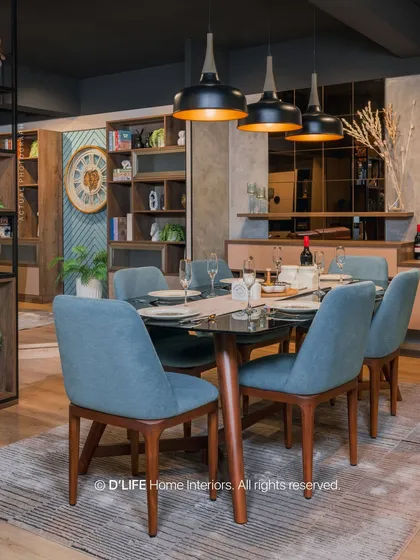 This dining area showcases contemporary grandeur with its dark wood table, blue upholstered chairs, and dramatic pendant lighting, creating a sophisticated atmosphere for meals.