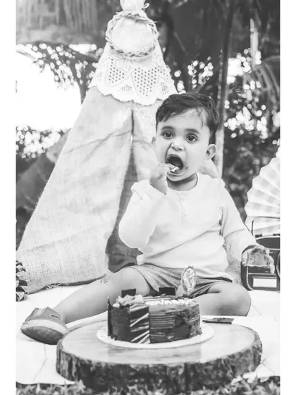 A black and white shot of Ivaan enjoying his birthday cake. The monochrome edit brings a different mood to the cake smash, focusing on the action and the textures.