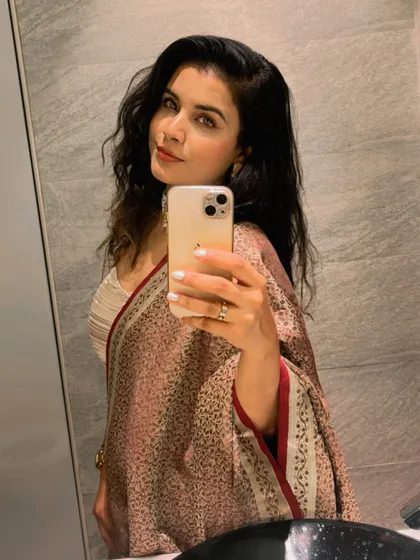 A mirror selfie from the same client, showing how the dupatta, made from her mother's saree, drapes beautifully with her fusion outfit and the elegant pearl choker.