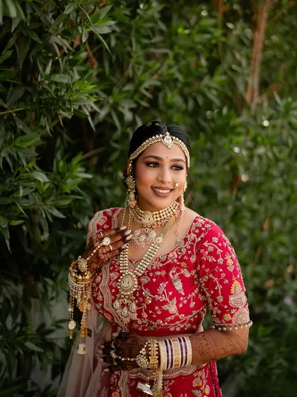 A stunning bride in a red lehenga, adorned with layered pearl and kundan jewellery from my collection.