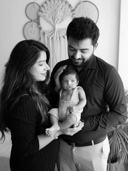 A tender black and white portrait of a new family. The parents look down at their baby with so much love, and I use soft lighting to create a gentle, intimate mood.