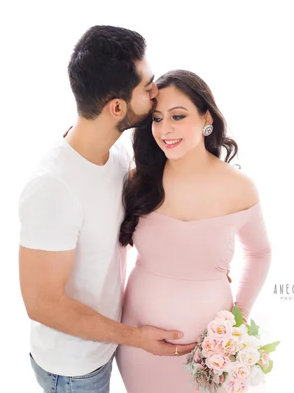 A gentle forehead kiss is a simple gesture that conveys so much love and protection. It's a perfect, tender moment to capture during a couple's maternity session.