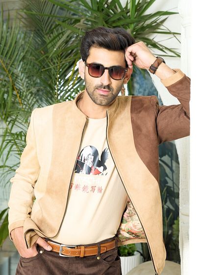 The two-toned suede jacket is shown here as a versatile layering piece over a graphic tee, perfect for creating a look that is both dapper and relaxed.