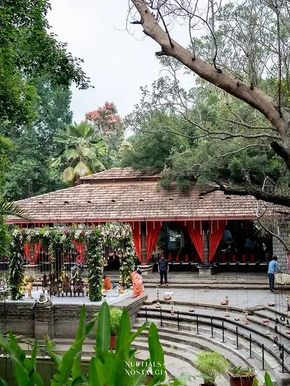 A wide shot of the Pond Pavilion, decorated with red drapes, ready for a vibrant and traditional wedding ceremony.