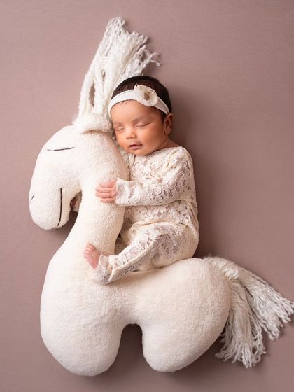 A top-down view of the horse prop setup. This pose is done safely with support to ensure the baby is secure and comfortable at all times.