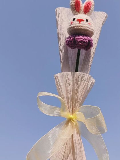 The bunny bouquet held up against a clear blue sky.
