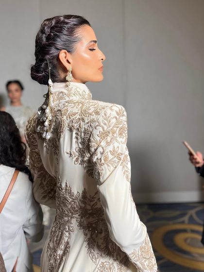 The back view of the intricate hair and stunning outfit from the Manish Malhotra couture show. The detailed braid work adds a layer of sophistication to the overall bridal look.