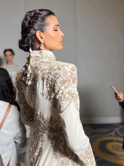 A view of the detailed hair and makeup from the back, showing the craftsmanship that goes into a complete runway look.