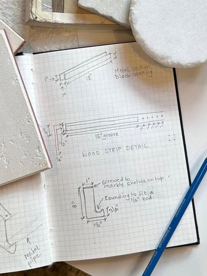 A sketchbook page with detailed drawings for a wood strip detail, next to a textured material sample. This shows how we resolve technical details at the micro-level to ensure a flawless finish.