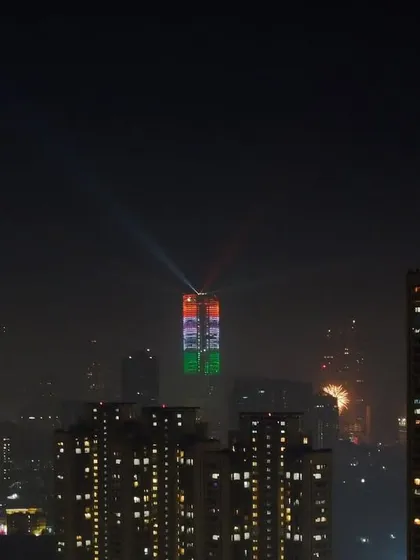 The Palais Royale building in Mumbai is lit up with the colors of the Indian flag for Republic Day, with spotlights shining into the night sky.