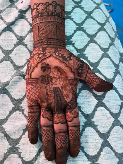 A groom's mehendi featuring a portrait of the couple. It's a beautiful way for the groom to carry a symbol of his love on his wedding day.