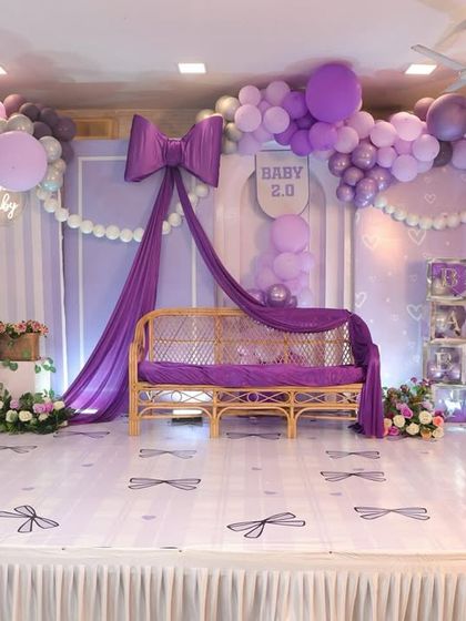The full stage setup for the bow-themed baby shower, complete with teddy bears, floral arrangements, and a beautiful balloon garland.