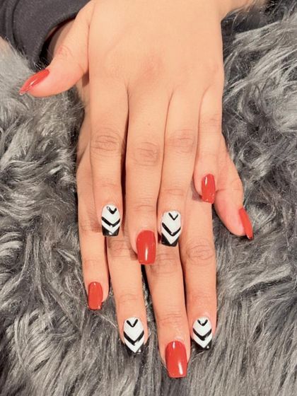 A close-up of the bold red and geometric chevron nail art, showing the clean lines and high-contrast design.