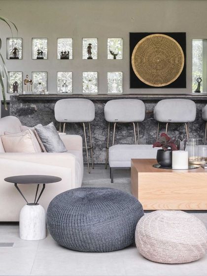 The bar in the lounge is a centerpiece, built from rustic grey marble with brass trimmings. Niches in the wall showcase sculptures from the family's art collection.