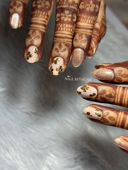 Another look at these elegant engagement nails. The gold floral details really pop against the soft nude base.