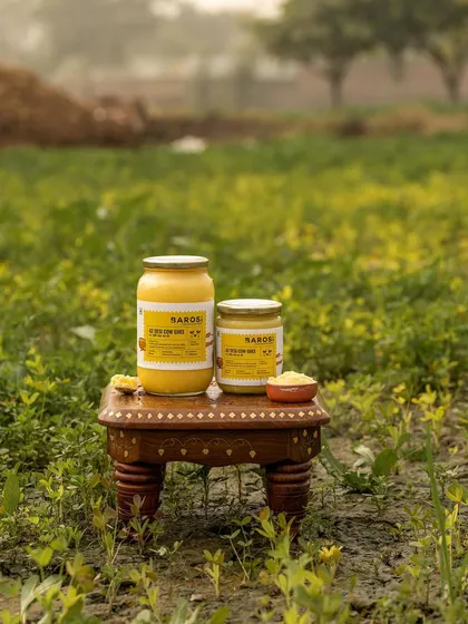 Barosi's ghee products photographed in a green field. This environmental shot powerfully communicates the brand's message of natural, farm-sourced ingredients.