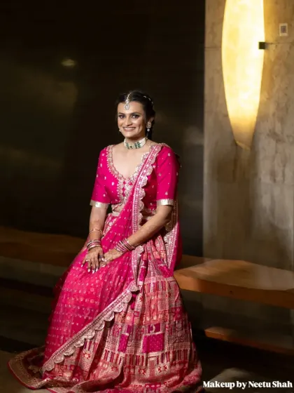 A poised and elegant portrait. The rich pink of her outfit is complemented by the soft, radiant makeup.