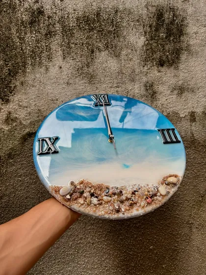 This giveaway post features the beautiful ocean-themed wall clock. The vibrant blue of the water contrasts perfectly with the natural sand, making it a stunning piece of home decor.