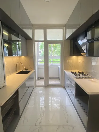 A kitchen should be as functional as it is beautiful. This modular galley kitchen features a sleek, handleless design, ample storage, and under-cabinet lighting for a practical and modern cooking space.