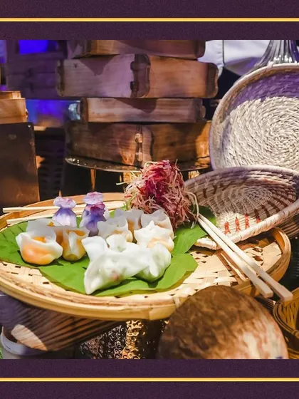 Our dim sum station at a glamorous event, featuring a variety of delicately crafted dumplings presented on a banana leaf in a traditional woven basket.