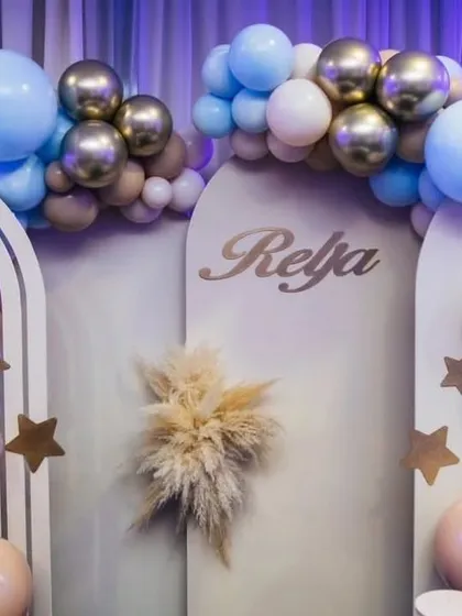 A detail shot of the custom arched backdrops and balloon work for Reja's first birthday. The combination of pastel blue, beige, and chrome gold balloons creates a soft, modern look.