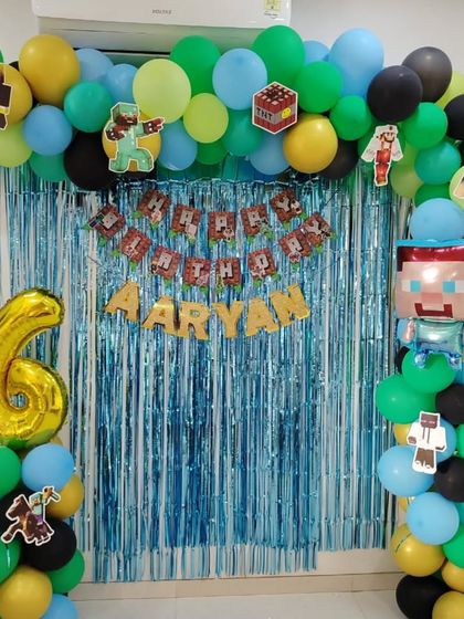 A Minecraft-themed birthday decoration for Aryan's 6th birthday. I used a blue foil curtain and a balloon arch in game-inspired colors, complete with character cutouts and a large number '6' foil balloon.