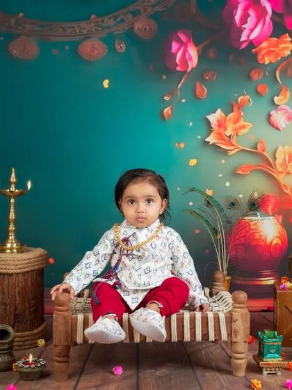 A festive and vibrant setup for this little one. The rich colors, traditional lamps, and floral backdrop create a beautiful, celebratory atmosphere for a milestone shoot.