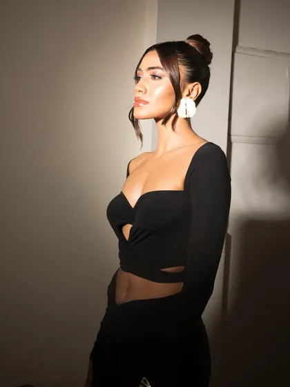A profile view that highlights the glowing skin and the elegant silhouette created by the hair and outfit.
