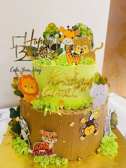 A wild adventure begins at one. This two-tier jungle cake combines a tree trunk base with a grassy green top tier, filled with cute animal toppers.