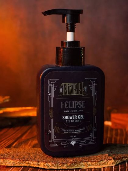 A close-up of the shower gel bottle, with dramatic orange and blue lighting. This highlights the product's label and design while creating a powerful visual.