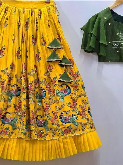 A deconstructed view of the peacock-print lehenga, which can be paired with a different style of blouse, like this green one.