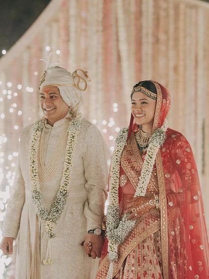 Tanya and Suyash walk hand-in-hand, surrounded by sparklers. Their bright smiles show the pure happiness of being pronounced husband and wife.