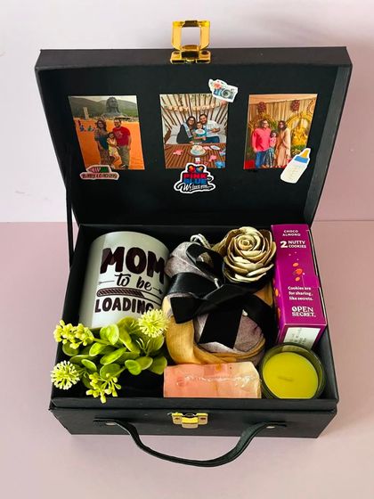 Inside the "Mom To Be" hamper, you'll find a custom mug, a scented candle, cookies, and other pampering items. I also add photos to the lid for a personal touch.