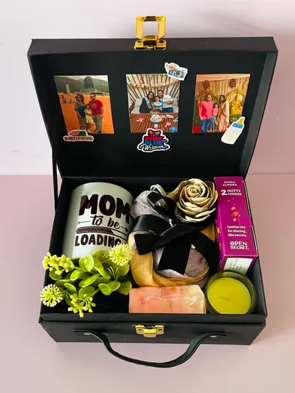 Inside the "Mom To Be" hamper, you'll find a custom mug, a scented candle, cookies, and other pampering items. I also add photos to the lid for a personal touch.
