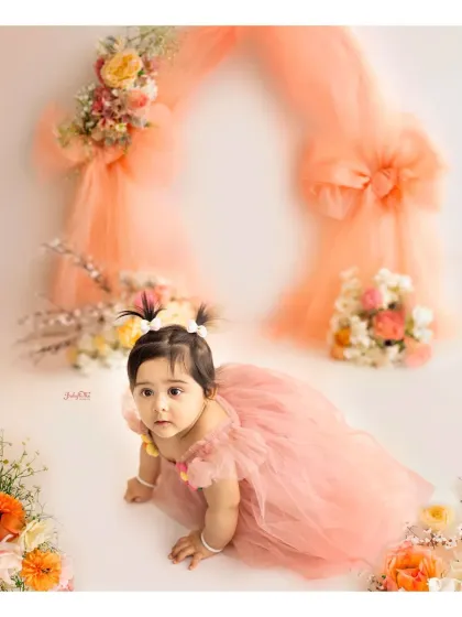 Capturing babies on the move is part of the fun. This crawling shot shows her beautiful dress and the dreamy, draped backdrop of the peach floral theme.