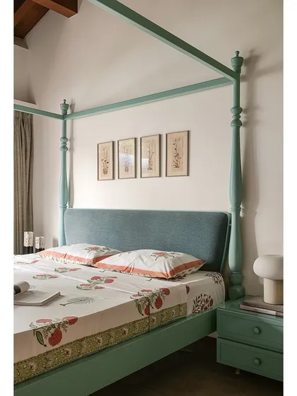 In this bedroom, a mint-green four-poster bed is paired with lilac-painted wardrobes. The contrast of colours, along with the traditional form of the bed and the simple lines of the cabinetry, creates a space that is both whimsical and contemporary.