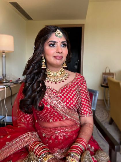 A classic seated portrait. Her makeup is soft and romantic, with rosy cheeks and a matching lip color.